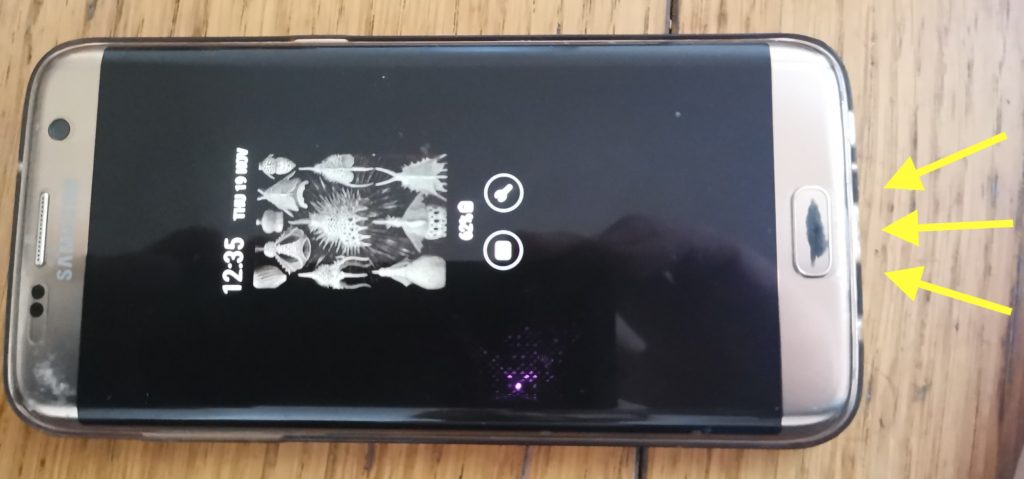 Photo of a Samsung phone with arrows pointing to the microphone location at the bottom on the phone (near the charging port).